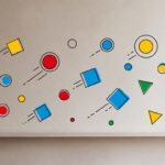Colorful geometric shapes—red circles, blue squares, yellow triangles, and green accents—arranged like orbiting particles on a clean wall, each moving in its own implied trajectory without touching, resembling atomic motion.